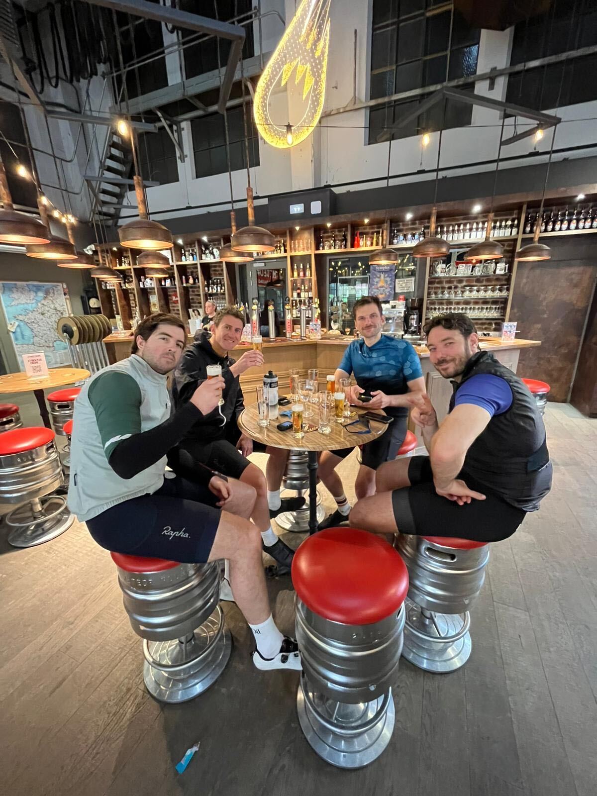 Post-ride beers on keg stools at a brewery bar