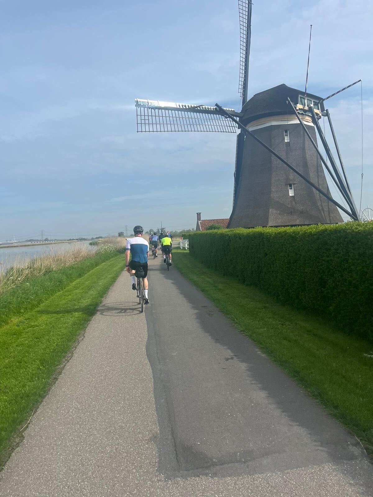 Cyclists passing a traditional Dutch windmill